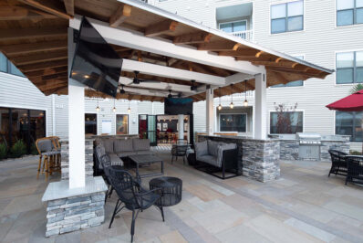 Outdoor lounge with TV and seating area