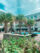 Palm trees next to a pool and outdoor grill